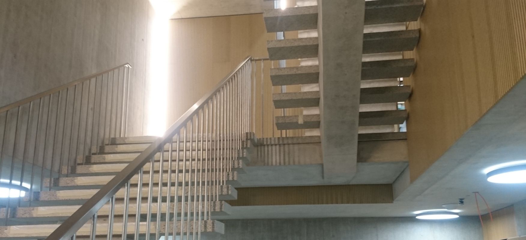 Escalier intérieur avec parapet et main courante en acier.